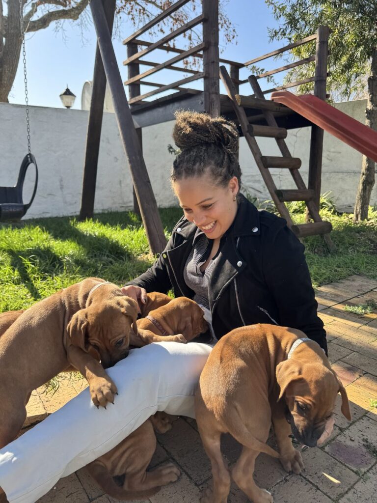 Kirstin Arendse, Accounting Manager at The Fitness CPA, playing with puppies